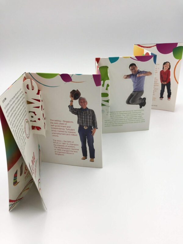 A creative corporate brochure with an accordion fold and intricate die-cut elements, featuring photos and text on each panel for an interactive experience.