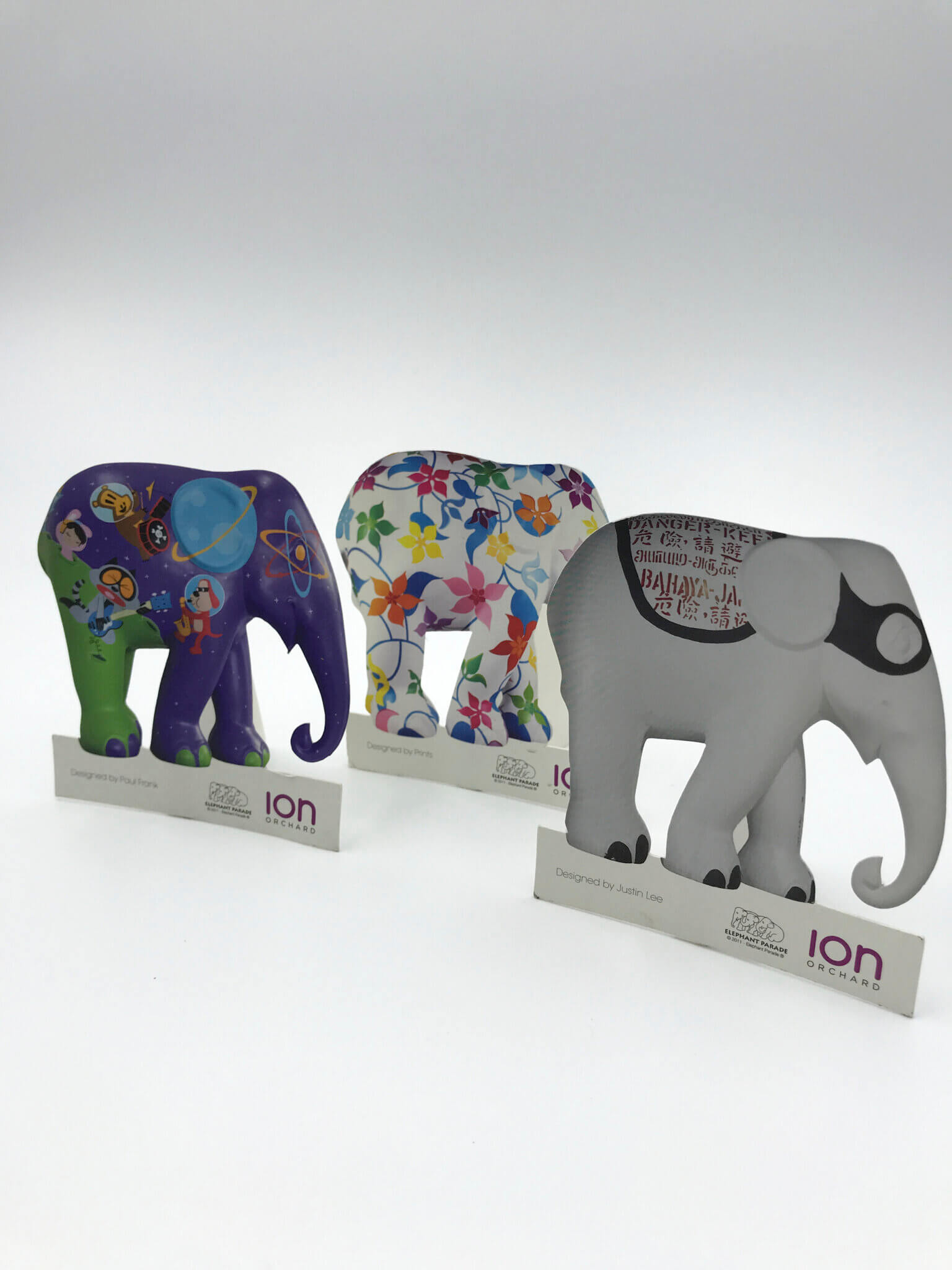 Three custom-printed and die-cut elephant figures, each with a unique artistic design, created as promotional items for the ION Orchard Elephant Parade event.