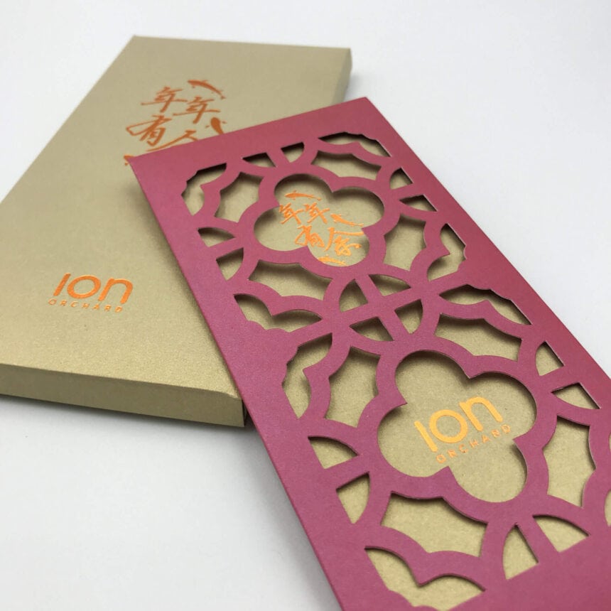 An elegant Chinese New Year red packet from ION Orchard, featuring an intricate laser-cut floral pattern on the sleeve