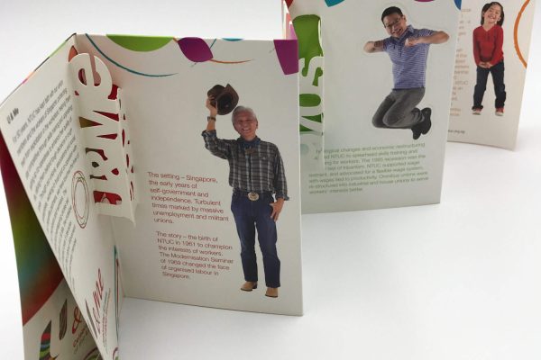 A creative corporate brochure with an accordion fold and intricate die-cut elements, featuring photos and text on each panel for an interactive experience.