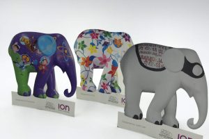 Three custom-printed and die-cut elephant figures, each with a unique artistic design, created as promotional items for the ION Orchard Elephant Parade event.