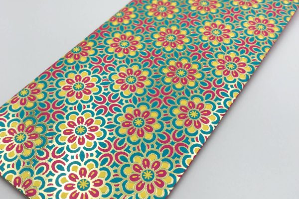 A sample of decorative paper showcasing intricate gold foil printing that outlines a vibrant