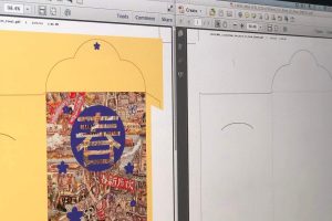 A pre-press designer's computer screen showing a digital proof, with the full-color artwork for a festive envelope on the left and its corresponding die-cut template on the right.