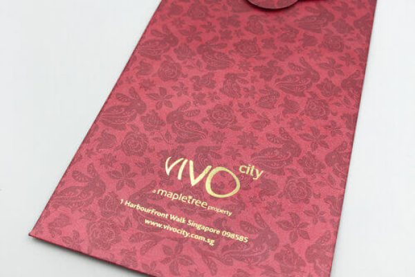 The back of a custom-printed red packet for VivoCity, showcasing a subtle tonal pattern of rabbits and flowers and the corporate logo stamped in gold foil